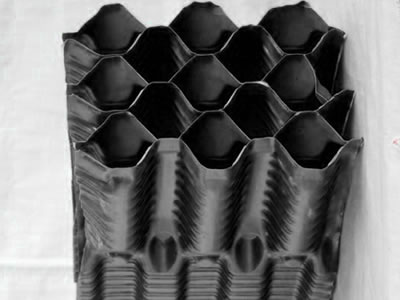 There is one mass of black cooling tower vertical fill, the side face of it has honeycomb profile.